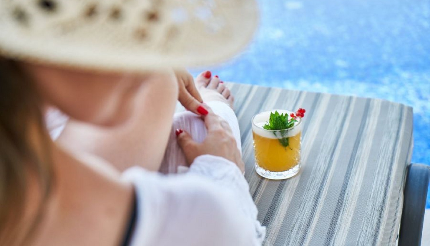 Lady with holiday drink by the pool