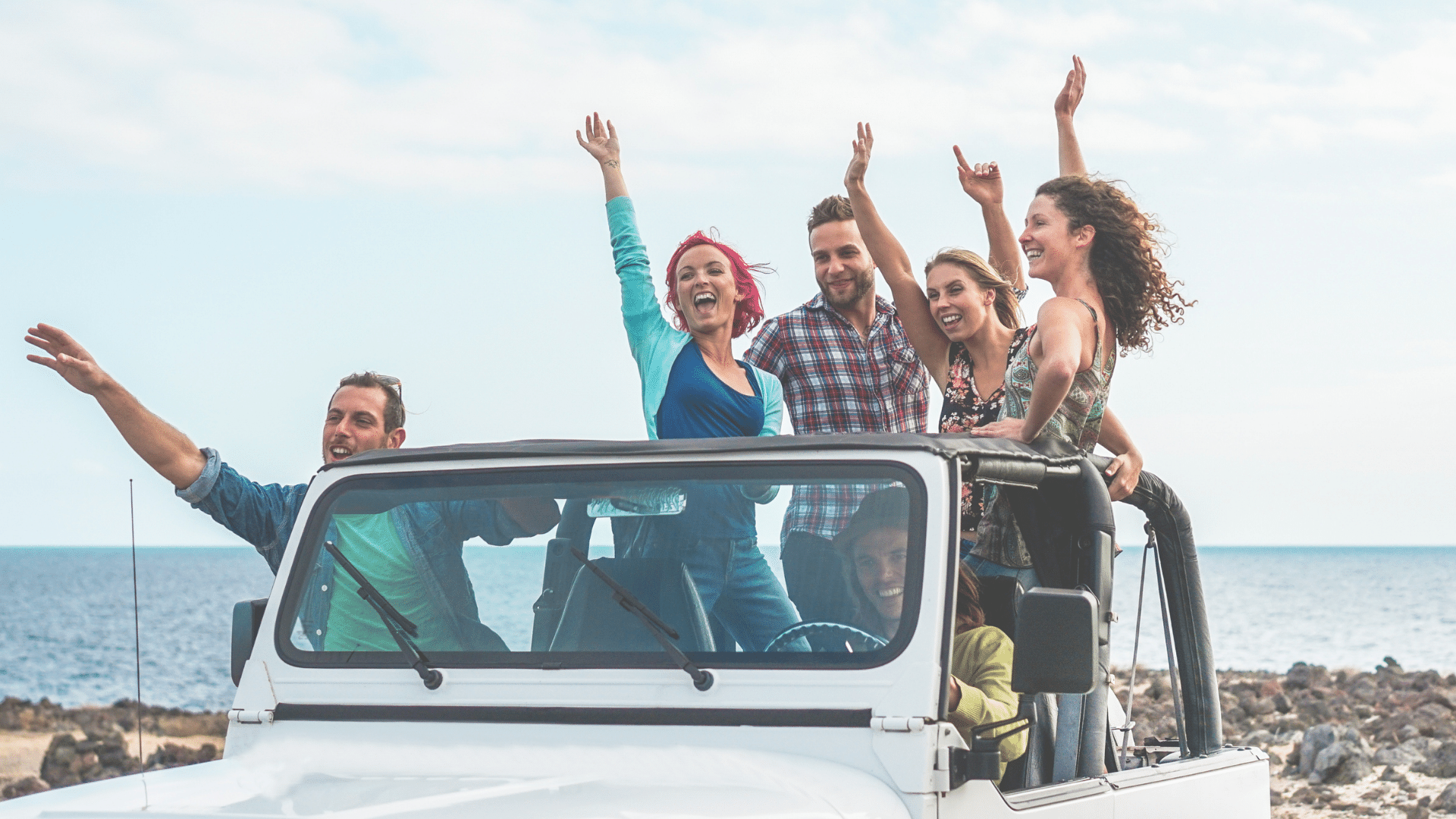 friends in a jeep by the ocean