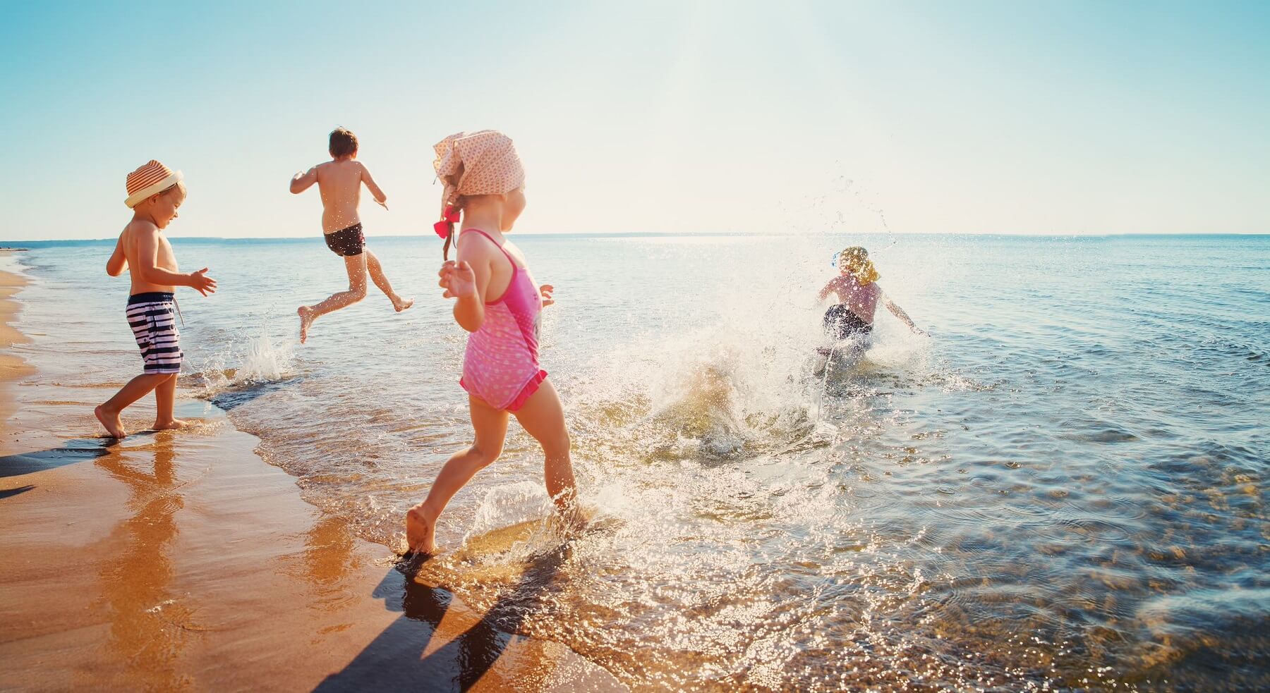 children running into the ocean