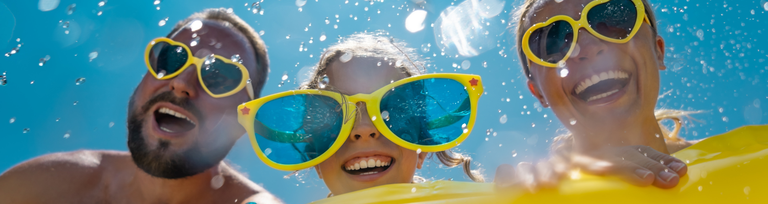 family of three at water park with yellow sunglasses