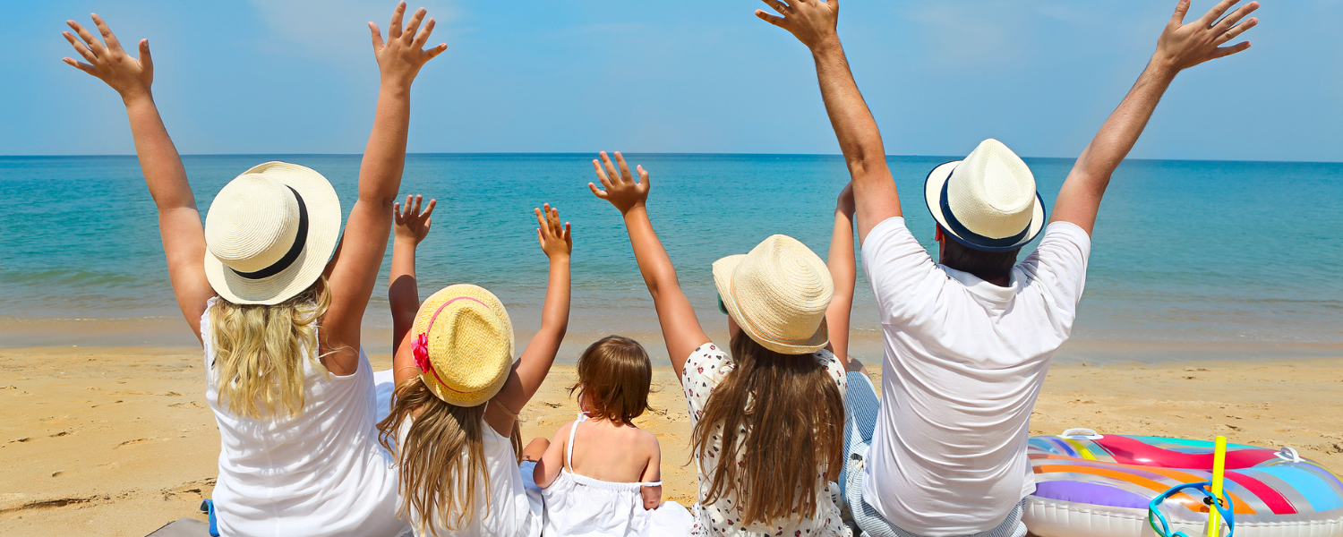 family of five sitting on the beach